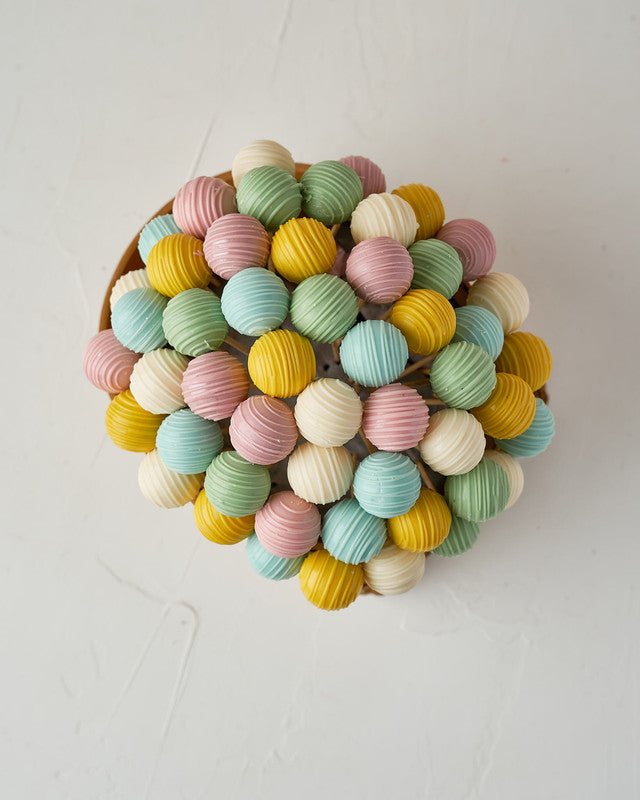 Spring Truffle BasketChocolate & ConfectioneryYour Gift Contains: • 53 assorted truffles • Flavors: Pistachio, Sepculoos, Hazelnut, Rice Crispy, Peanut Butter, Kinder and Roche • Basket Size: 15x20x12 cm Handling and Storage • Keep away from direct heat a