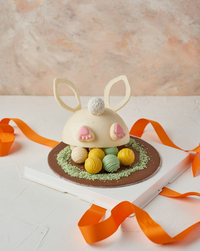 Bunny DiggingChocolate & ConfectioneryYour Gift Contains: • 200grams white chocolate Pinata • 8 assorted truffles in Kinder, Pistachio and Biscoff flavors • 1 x Hammer • Box Size: 23x23x26 cm Handling and Storage • Keep away from direct heat and sunlight