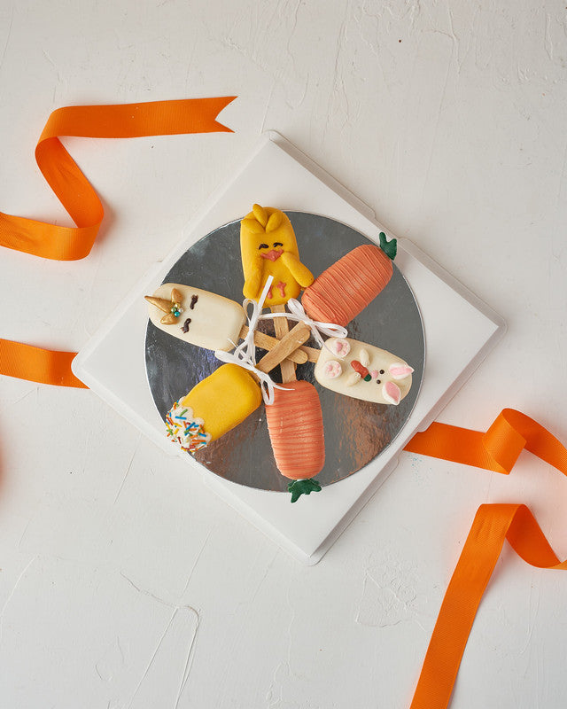 Easter Theme CakesiclesChocolate & ConfectioneryYour Gift Contains: • 3 Red Velvet and 3 Vanilla Cakesicles • Designed as carrots, bunny, unicorn, and chick • Box Size: 23x23x14cm Handling and Storage • Keep away from direct heat and sunlight • Best store