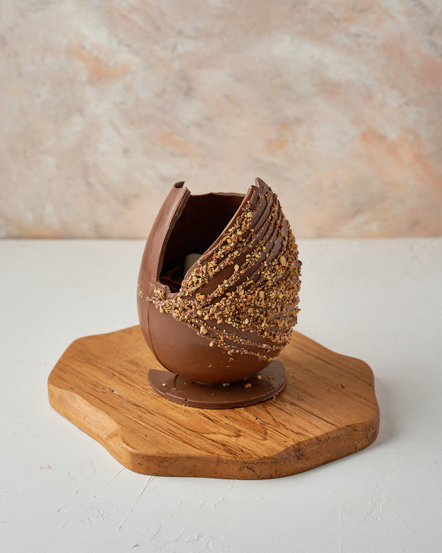 Hazelnut Crunch Easter EggChocolate & ConfectioneryYour Gift Contains: • 600 grams milk chocolate roasted Hazelnut egg • Fillings: Marshmallows, Pretzels, Drageè • Box Size: 13x13x26cm Handling and Storage • Keep away from direct heat and sunlight • Best