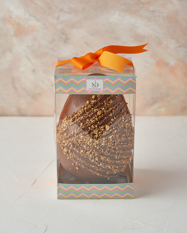 Hazelnut Crunch Easter EggChocolate & ConfectioneryYour Gift Contains: • 600 grams milk chocolate roasted Hazelnut egg • Fillings: Marshmallows, Pretzels, Drageè • Box Size: 13x13x26cm Handling and Storage • Keep away from direct heat and sunlight • Best