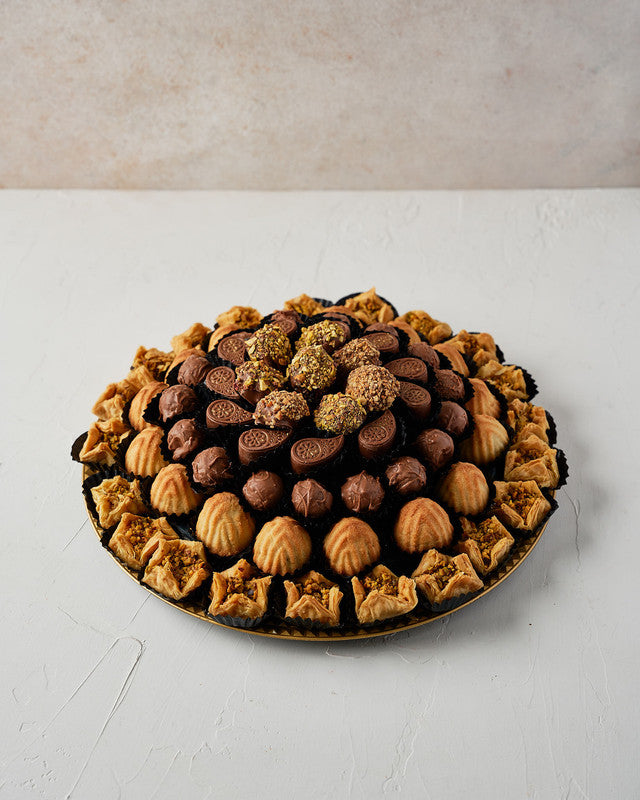 Baklawa, Mamoul and Dates Assorted Arrangement by NJDChocolate & ConfectioneryYour Gift Contains: • 6 pieces chocolate covered dates with roasted Pistachio • 21 pieces Baklawa Bookaj • 16 pieces Mamoul • 16 pieces Milk chocolate truffles • 11 pieces assor