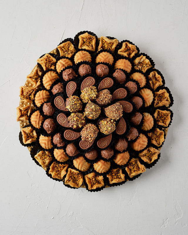 Baklawa, Mamoul and Dates Assorted Arrangement by NJDChocolate & ConfectioneryYour Gift Contains: • 6 pieces chocolate covered dates with roasted Pistachio • 21 pieces Baklawa Bookaj • 16 pieces Mamoul • 16 pieces Milk chocolate truffles • 11 pieces assor