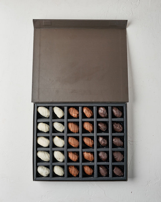30pcs Chocolate Covered DatesChocolate & ConfectioneryYour Gift Contains: • 10 White chocolates covered Majdoul dates • 10 Milk chocolates covered Majdoul dates • 10 Dark chocolates covered Majdoul dates • Box Size: LxBxH: 32x25.5x3cm Handling and Storage