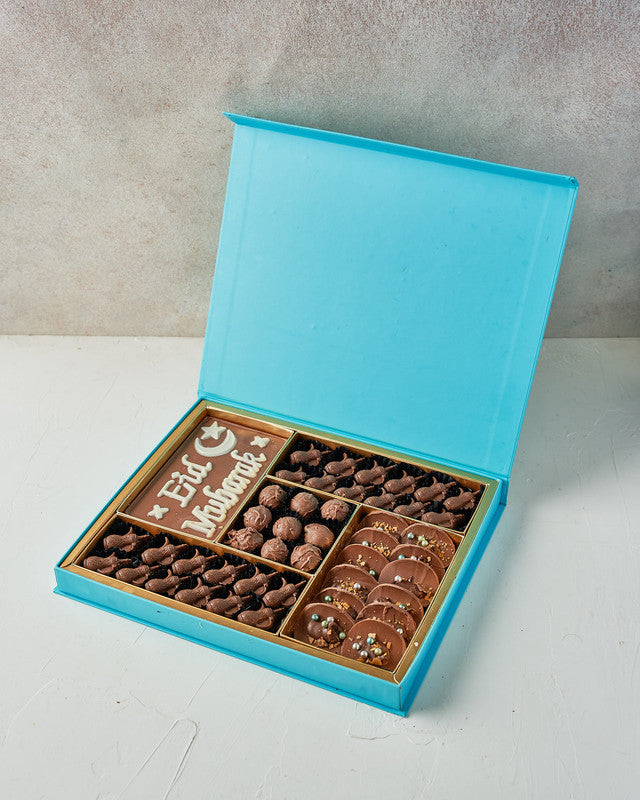 Assorted EID Gift Box by NJDChocolate & ConfectioneryYour Gift Contains: • EID Mubarak Chocolate bar: 25ogms • 24 assorted milk chocolates • Flavours: Pistachio, Peanut Butter, Hazelnut and Dates • 9 milk chocolate truffles • 12 Milk chocolate Tacos • Box