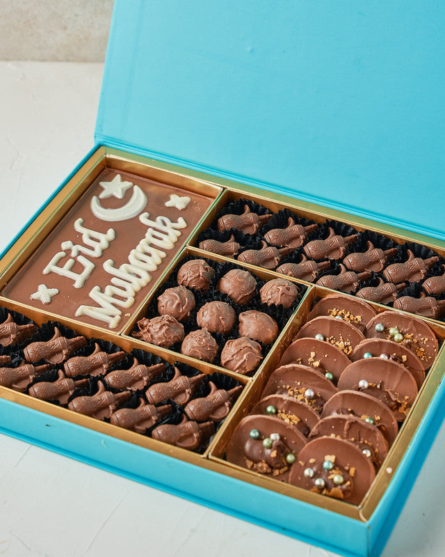 Assorted EID Gift Box by NJDChocolate & ConfectioneryYour Gift Contains: • EID Mubarak Chocolate bar: 25ogms • 24 assorted milk chocolates • Flavours: Pistachio, Peanut Butter, Hazelnut and Dates • 9 milk chocolate truffles • 12 Milk chocolate Tacos • Box