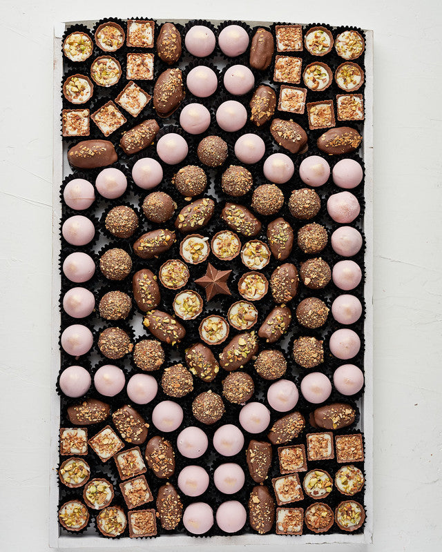 EID Gift Arrangment by NJDChocolate & ConfectioneryYour Gift Contains: • 37 Ruby chocolate assorted truffles • 19 Milk chocolate roasted Almond truffles • 23 Pistachio Praline chocolates • 20 Almond Praline • 23 Chocolate covered Majdoul dates • Tray Size