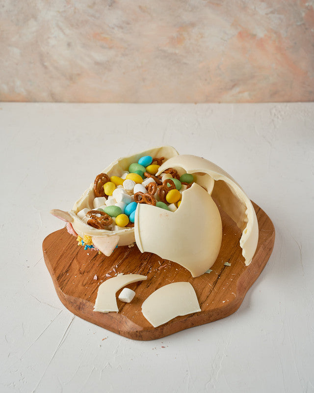 Purple Easter EggChocolate & ConfectioneryYour Gift Contains: • Milk and Color chocolate marble effect chocolate egg • Fillings: Pretzels, Mini marshmallows, drageè • Egg Size: 12.5×12.5x 20cm • Box Size: 13x13x22cm Handling and Storage • Keep away from d