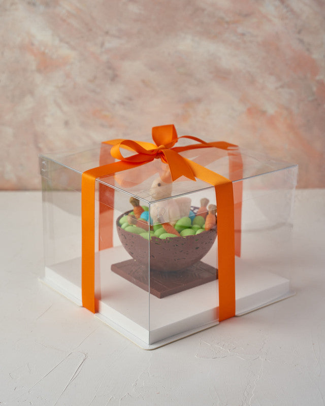 Bunny and CarrotsChocolate & ConfectioneryYour Gift Contains: • Chocolate bowl: 200 grams • Edible chocolate carrots: 7 pieces • Drageè: 300grams approx. • White chocolate bunny • Box Size: 20x20x24cm Handling and Storage • Keep away from direct heat and