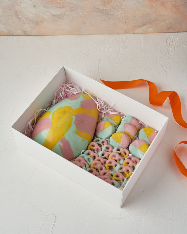 Easter AssortmentChocolate & ConfectioneryYour Gift Contains: • 200 gram multi color Belgian chocolate egg • Chocolate covered Pretzels: 200 grams • Multi color chocolate Oreos: 14 pieces • Box Size: 20.5x28x9cm Handling and Storage • Keep away from direc