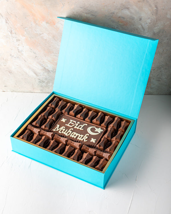 EID Greetings 34pcsSweetsYOUR GIFT CONTAINS 34pcs assorted milk chocolates filled with hazelnut, dates and Peanut butter, lotus and pistachio praline flavor 50gms Milk chocolate slab with EID Mubarak Message Box/Tray Size: LxBxH: 31x 25.5x6cm HANDLING AND