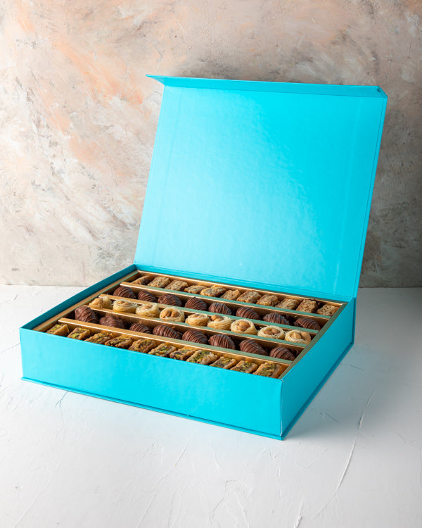Baklawa and Dates Gift box by NJDSweetsYour Gift Contains: Assorted Baklawas: 31pcs Belgian Milk Chocolate Covered Dates: 16 pieces Box/Tray Size: LxBxH: 31x25x5cm HANDLING AND STORAGE Keep away from direct heat and sunlight Keep it refrigerated Suitable