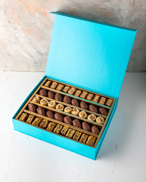 Baklawa and Dates Gift box by NJDSweetsYour Gift Contains: Assorted Baklawas: 31pcs Belgian Milk Chocolate Covered Dates: 16 pieces Box/Tray Size: LxBxH: 31x25x5cm HANDLING AND STORAGE Keep away from direct heat and sunlight Keep it refrigerated Suitable