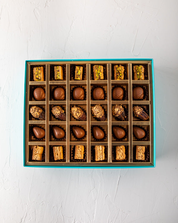 Baklawa, Dates and Chocolate Gift by NJDSweetsYour Gift Contains: Pistachio Baklawa: 6pcs Almond Baklawa: 6pcs Assorted Milk Chocolate: 12pcs Chocolate covered roasted nuts dates: 6pcs Box/Tray Size: LxBxH: 32x25x5cm HANDLING AND STORAGE Keep away from di