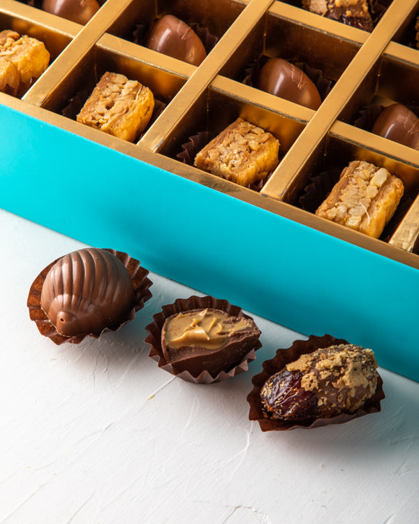 Baklawa, Dates and Chocolate Gift by NJDSweetsYour Gift Contains: Pistachio Baklawa: 6pcs Almond Baklawa: 6pcs Assorted Milk Chocolate: 12pcs Chocolate covered roasted nuts dates: 6pcs Box/Tray Size: LxBxH: 32x25x5cm HANDLING AND STORAGE Keep away from di