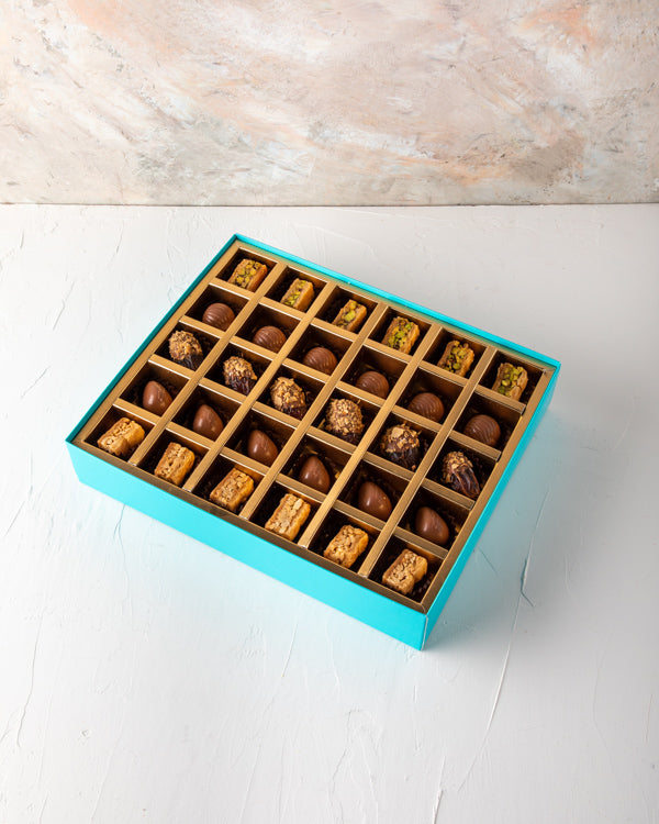Baklawa, Dates and Chocolate Gift by NJDSweetsYour Gift Contains: Pistachio Baklawa: 6pcs Almond Baklawa: 6pcs Assorted Milk Chocolate: 12pcs Chocolate covered roasted nuts dates: 6pcs Box/Tray Size: LxBxH: 32x25x5cm HANDLING AND STORAGE Keep away from di