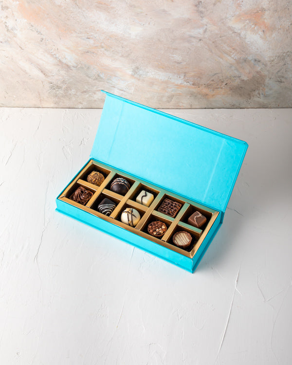 Small Assorted Box by NJDSweetsYour Gift Contains: 10 pieces assorted chocolates in Milk, Dark and White chocolate - Lotus - Hazelnut - Pistachio - Salted Caramel - Peanut Butter Box/Tray Size: LxBxH: 25x12x4cm HANDLING AND STORAGE Keep away from direct h