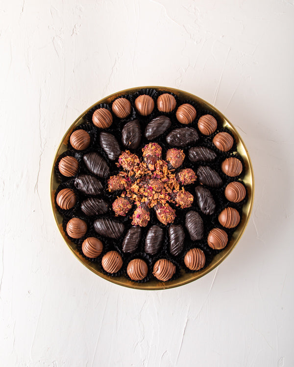 EID Gift, Truffles and Dates Arrangement by NJDSweetsYour Gift Contains: Gold metal luxurious tray decorated with truffles and dates Belgian Milk chocolate truffles: 20 pieces Dark chocolate dates: 15 pieces Rose Date: 11 pieces Box/Tray Size: LxBxH: 30x5