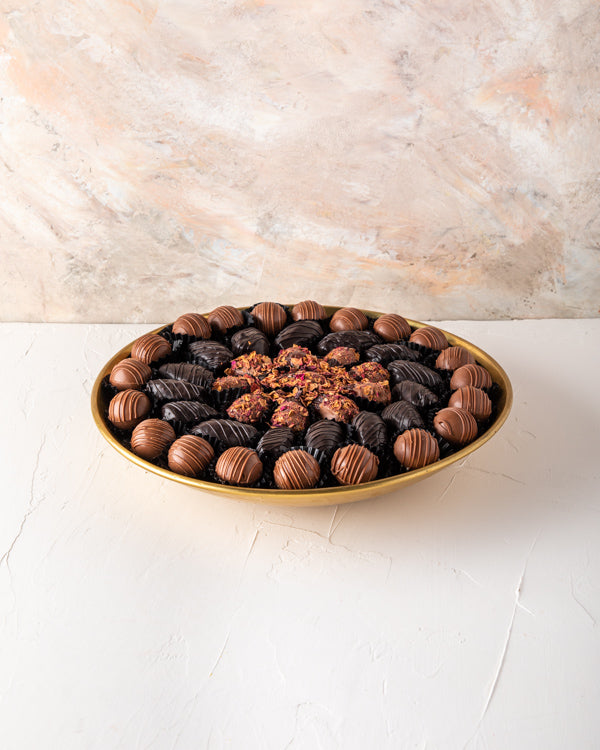 EID Gift, Truffles and Dates Arrangement by NJDSweetsYour Gift Contains: Gold metal luxurious tray decorated with truffles and dates Belgian Milk chocolate truffles: 20 pieces Dark chocolate dates: 15 pieces Rose Date: 11 pieces Box/Tray Size: LxBxH: 30x5