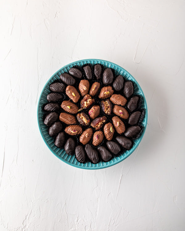 Luxury Dates Collection by NJDNuts Dates & Dried FruitsYour Gift Contains: The stoneware collection decorated with 40 pieces large, organic dates Dark chocolate dates: 22 pieces Milk chocolate Dates: 13 pieces Stuffed Dates: 4 pieces Rose: 1 piece Box/Tra