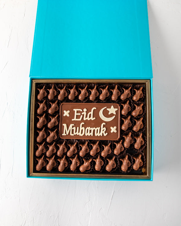 Eid Greetings 41pcs by NJDSweetsYOUR GIFT CONTAINS 41pcs assorted milk chocolates filled with hazelnut, dates and Peanut butter, lotus and pistachio praline flavor 50gms Milk chocolate slab with EID Mubarak Message Box/Tray Size: LxBxH: 31x 25.5x6cm HANDL