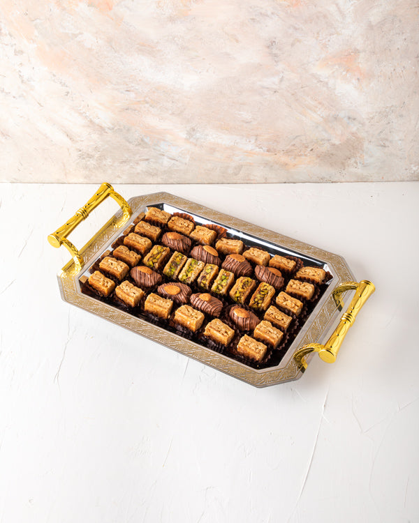 Baklawa and Tray Arrangement by NJDSweetsYour Gift Contains: Milk Chocolate Dates with Almond: 8 pieces Almond Baklawa: 21 pieces Pistachio Baklawa: 7 pieces Box/Tray Size: LxBxH: 35.5x25.6cm HANDLING AND STORAGE Keep away from direct heat and sunlight Ke
