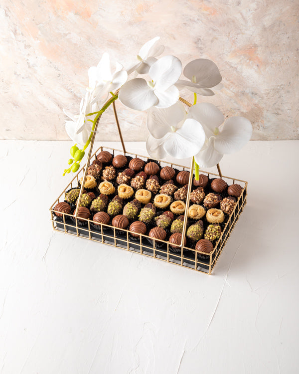 Assorted Ramadan Hamper by NJDSweetsYour Gift Contains: Assorted Belgian milk chocolate truffles: 17pieces Chocolate and Pistachio Dates: 10 pieces Chocolate and Roasted Almonds Dates: 10pieces Baklawa: 8pieces Box/Tray Size: LxBxH: 30x20.5x31.5cm HANDLIN