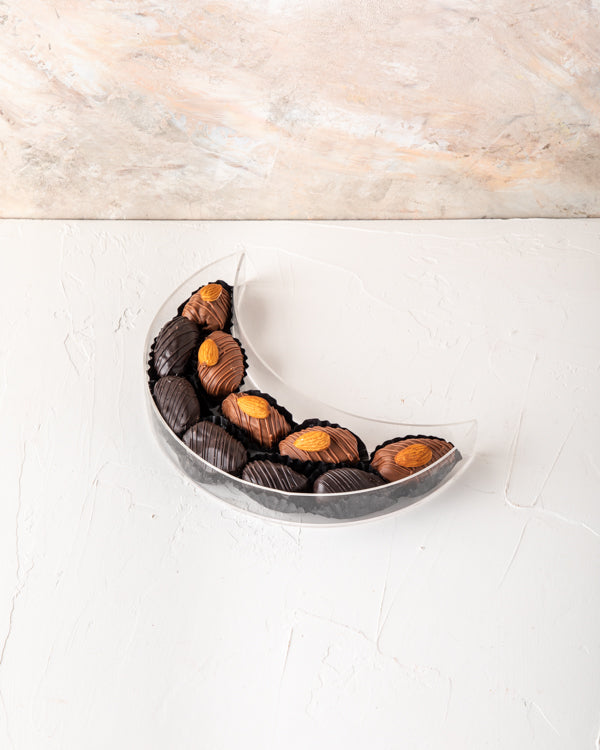 Crescent Dates Collection by NJDChocolate & ConfectioneryYour Gift Contains: Milk chocolate Almond dates - 5pcs Dark Chocolate Covered Dates - 5pcs Box/Tray Size: LxBxH: 7.5x20x5cm HANDLING AND STORAGE Keep away from direct heat and sunlight Keep it refri