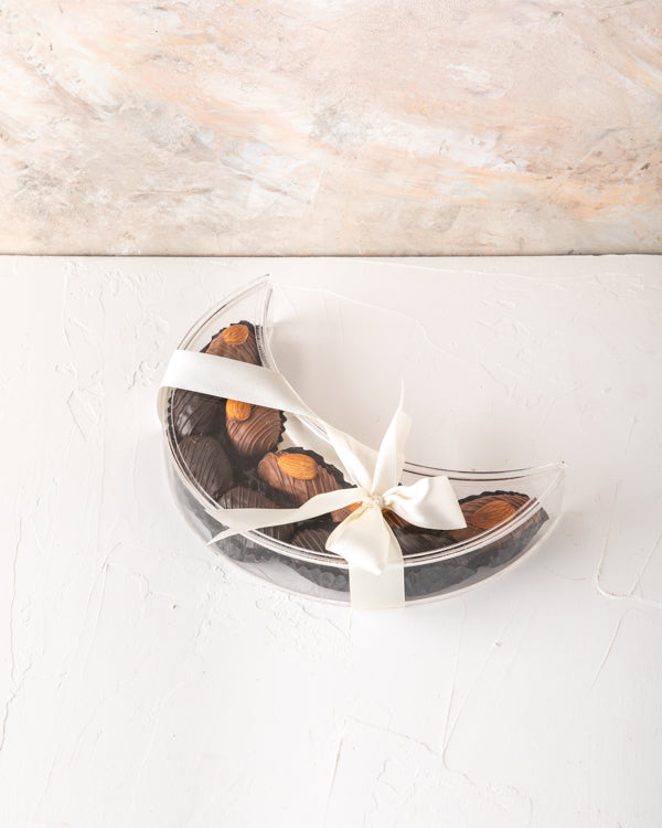 Crescent Dates Collection by NJDChocolate & ConfectioneryYour Gift Contains: Milk chocolate Almond dates - 5pcs Dark Chocolate Covered Dates - 5pcs Box/Tray Size: LxBxH: 7.5x20x5cm HANDLING AND STORAGE Keep away from direct heat and sunlight Keep it refri