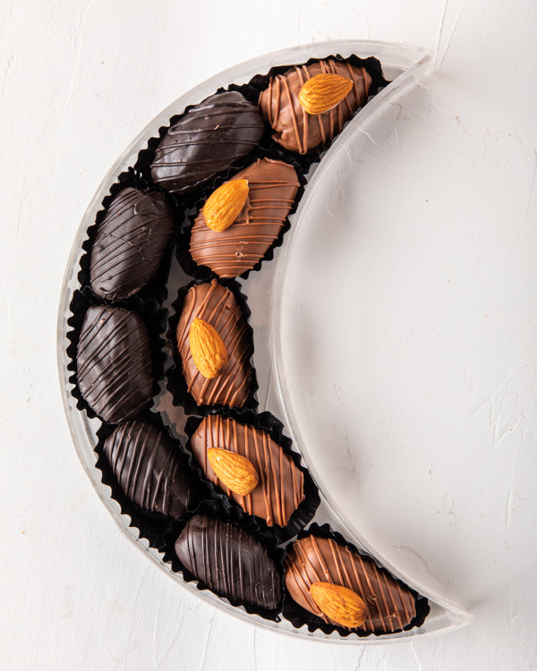 Crescent Dates Collection by NJDChocolate & ConfectioneryYour Gift Contains: Milk chocolate Almond dates - 5pcs Dark Chocolate Covered Dates - 5pcs Box/Tray Size: LxBxH: 7.5x20x5cm HANDLING AND STORAGE Keep away from direct heat and sunlight Keep it refri