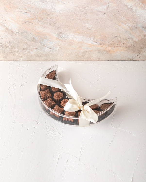 Crescent Chocolates Collection by NJDChocolate & ConfectioneryYour Gift Contains: Belgian milk assorted chocolates - 14 pieces Box/Tray Size: LxBxH: 7.5x20x5cm HANDLING AND STORAGE Keep away from direct heat and sunlight Keep it refrigerated Suitable for