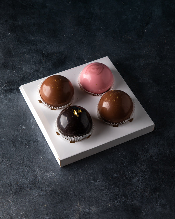 Hot Chocolate Bombs by NJDChocolate & ConfectioneryYour Gift Contains: A set of 4 hot chocolate bombs: Milk chocolate bomb: 2pcs Rose chocolate bomb: 1pcs Dark chocolate bomb: 1pcs Pour it in a cup of lukewarm/hot milk and enjoy Box/Tray Size: LxBxH: 18x1