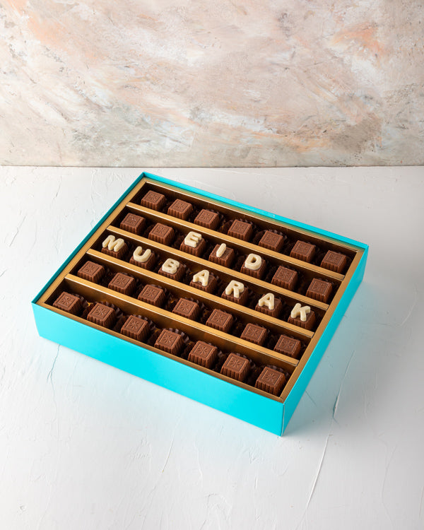 Eid Mubarak Customizable Box by NJDSweetsYOUR GIFT CONTAINS 35pieces of pure milk chocolate made with rich Belgian chocolate. Customize your EID greetings and make them feel special. Box/Tray Size: LxBxH: 31x 25.5x6cm HANDLING AND STORAGE Keep away from d